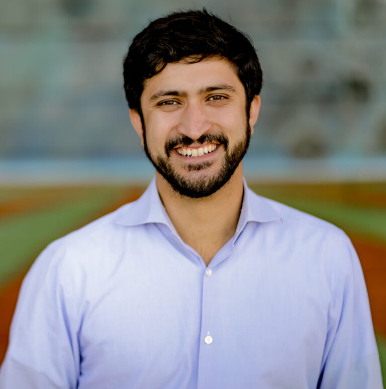 This is an image of Greg Casar, candidate for Texas's 37th Congressional District. He is pictured in a blue shirt standing on a field.