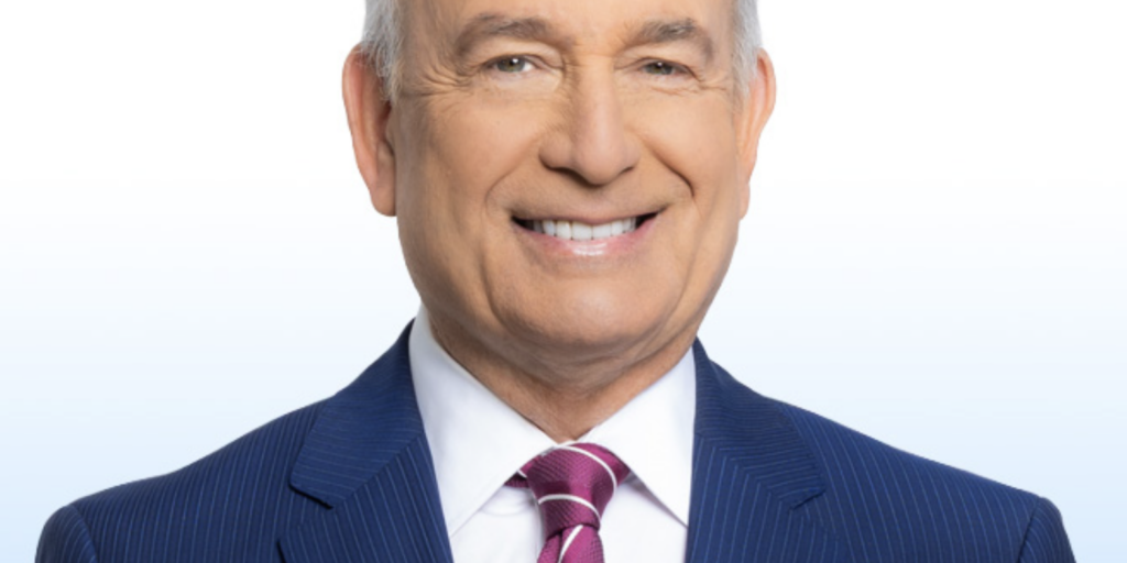 This is an image of Eliott Rodriguez, candidate for Florida's 27th Congressional District. He is pictured in a blue suit with a white shirt and red tie in front of a blue-white gradient background.